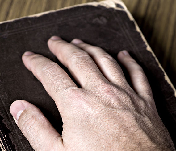 Dead man's act hand on bible