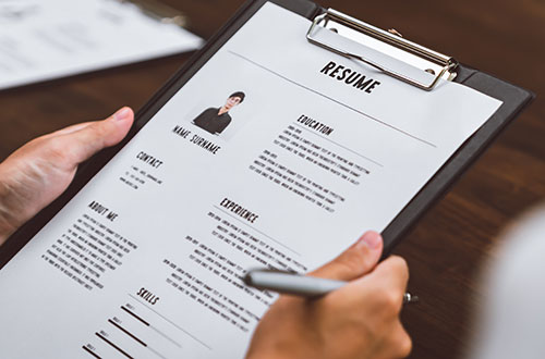 Employment law image of resume on a clipboard